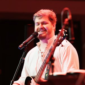 One Shot Bards - Concert d'un musicien souriant avec sa guitare sur scène