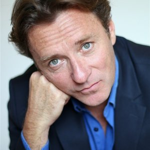 Alain CHAPUIS - Portrait d'un homme au regard réfléchi et au style élégant.