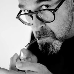 Steven DHONDT - Regard perçant: portrait en noir et blanc d'un homme allumant une cigarette