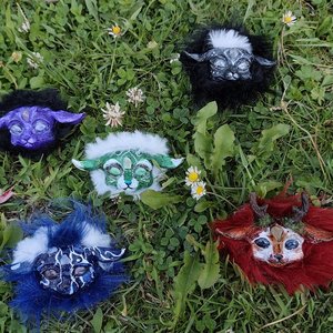 Petits masques féeriques colorés en fourrure disposés sur l'herbe avec marguerites.