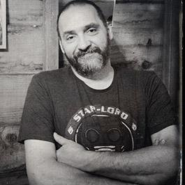 Jean-Louis MOURIER - Portrait chaleureux d'un homme barbu dans un décor de bois