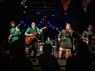 The Muddy Sates - Concert vibrant avec un groupe de musique sur scène et une foule enthousiaste.