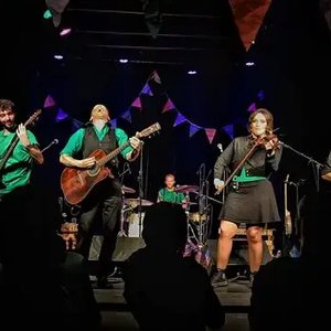 The Muddy Sates - Concert vibrant avec un groupe de musique sur scène et une foule enthousiaste.