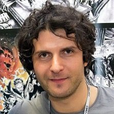 Gianluca GUGLIOTTA - Portrait d'un homme devant une affiche de bande dessinée