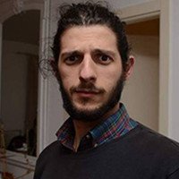 Nico TAMBURO - Portrait d'un homme au regard intense, barbe fournie et cheveux attachés