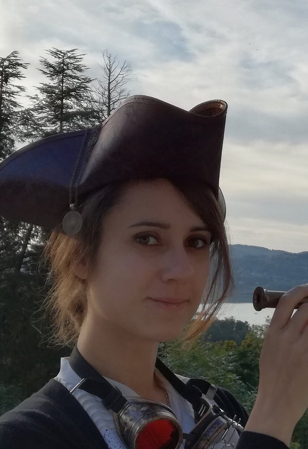 Ellie GREEN - Aventurière au bord de l'eau avec un chapeau de pirate et des lunettes steampunk