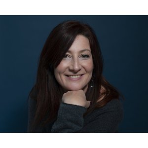 Vanessa ALTEMEYER - Portrait chaleureux avec un sourire éclatant sur fond bleu