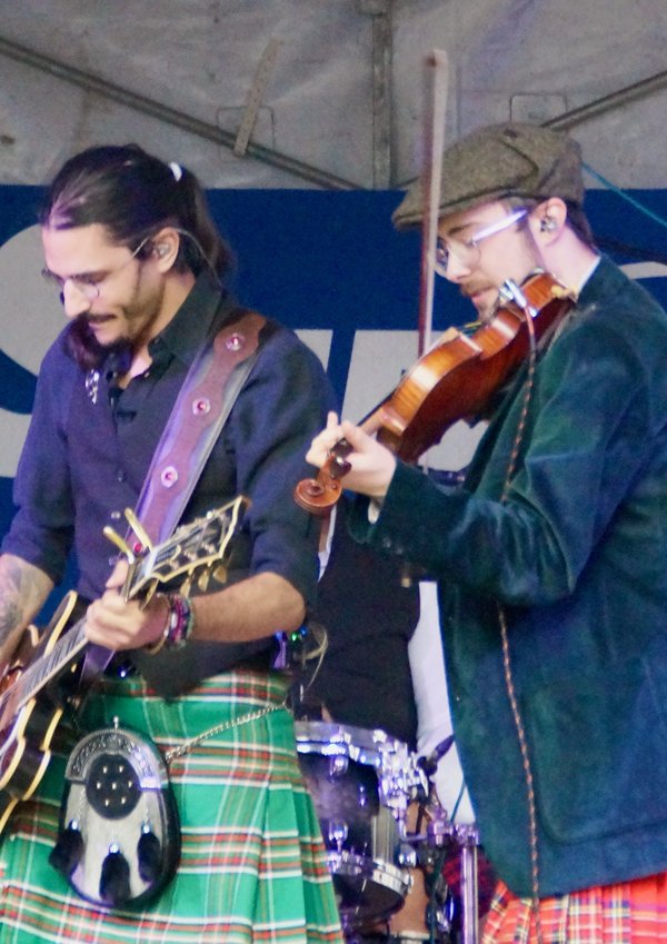 Deux musiciens en kilt jouant guitare et violon sur scène au festival Trolls & Légendes.