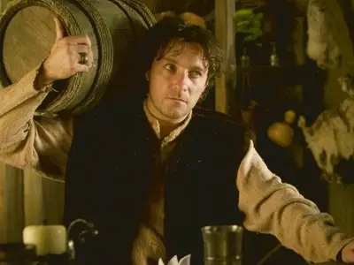 Alain CHAPUIS - Un homme du Moyen Âge dans une taverne avec un tonneau sur l'épaule