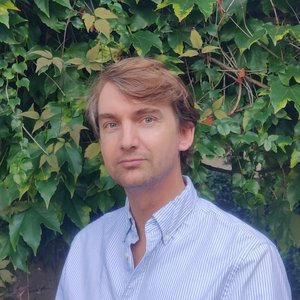 Alexandre DESOUTTER - Portrait d'un homme en chemise à rayures devant un mur de lierre