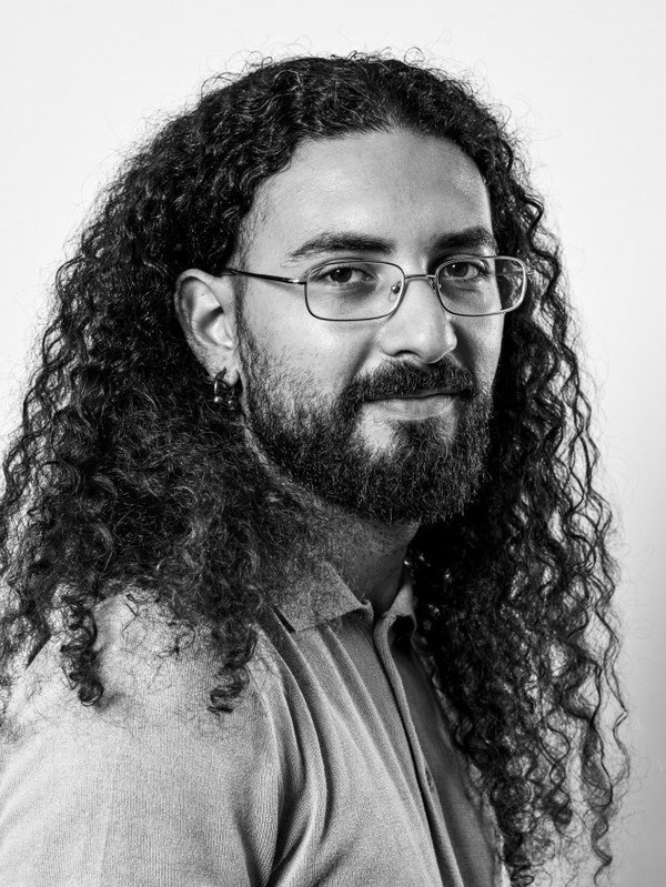 Pietrantonio BRUNO - Portrait en noir et blanc d'un homme aux cheveux bouclés et à lunettes.