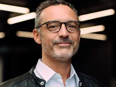 Arthur DE PINS - Portrait d'un homme au sourire confiant et à l'élégance moderne.