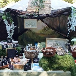 Étal de marché flore et herboristerie décoré de mousse, bocaux et paniers.