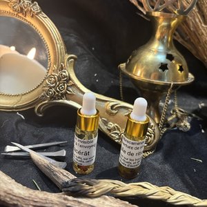 Deux fioles dorées d'huiles rituelles sur tissu noir, miroir ancien et encensoir.