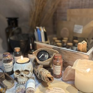 Autel ésotérique avec crâne, bougies, herbes, fioles et cristaux pour rituels.