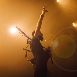 The Sidh - Émotion et énergie : un musicien en concert sous les lumières éclatantes.